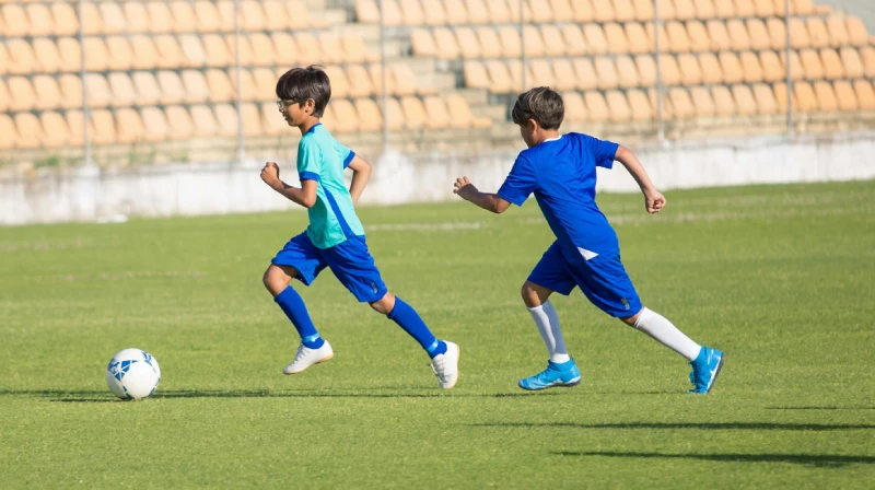 Two teenage boys playing football